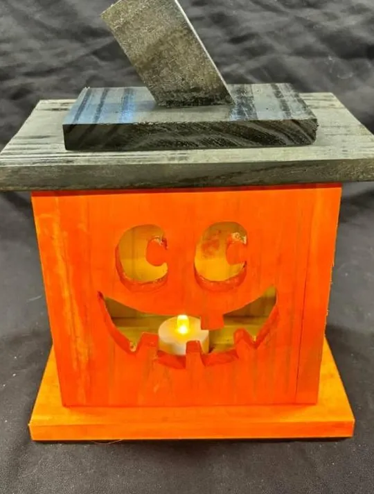 Orange wooden jack-o'-lantern LED tea-light lantern, lit